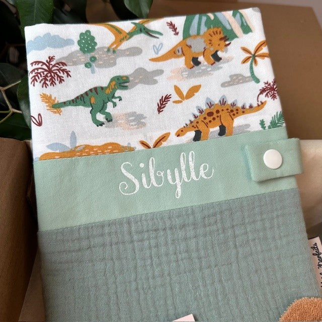 protège carnet de santé univers dinosaures personnalisé avec un prénom en écriture blanc scintillant chez Les petits parfaits