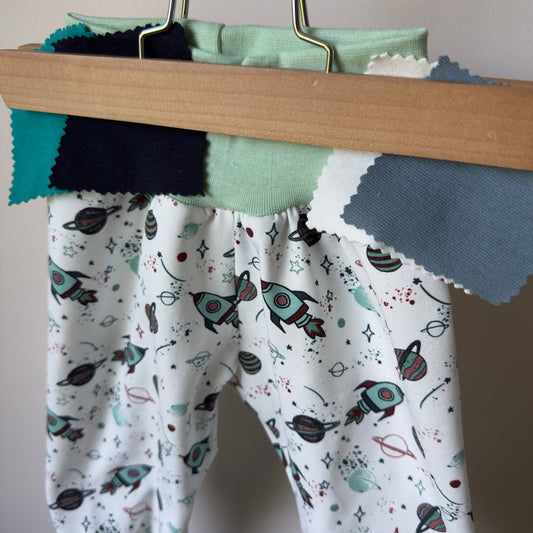 pantalon sarouel pour bébé avec de jolis motifs fusées et planètes dans les tons menthe sur fond blanc